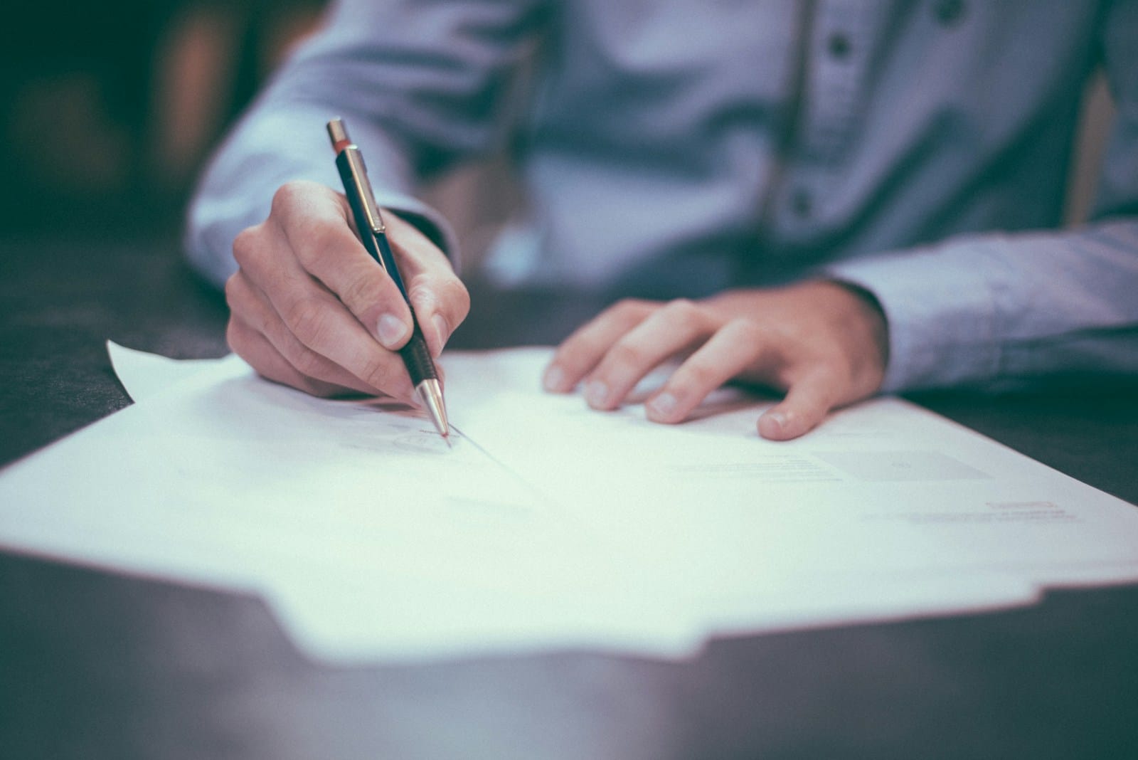 man writing on paper, kontrak jasa hukum